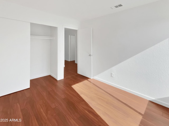 unfurnished bedroom with hardwood / wood-style flooring and a closet