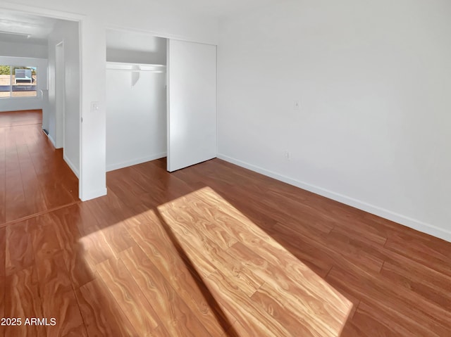 unfurnished bedroom with a closet and wood-type flooring