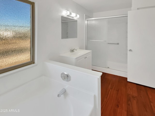 bathroom featuring plus walk in shower, hardwood / wood-style floors, and vanity