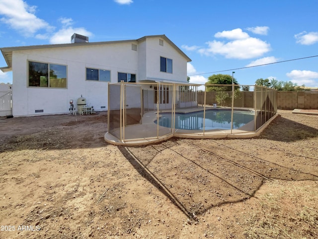 rear view of house featuring a patio and a fenced in pool