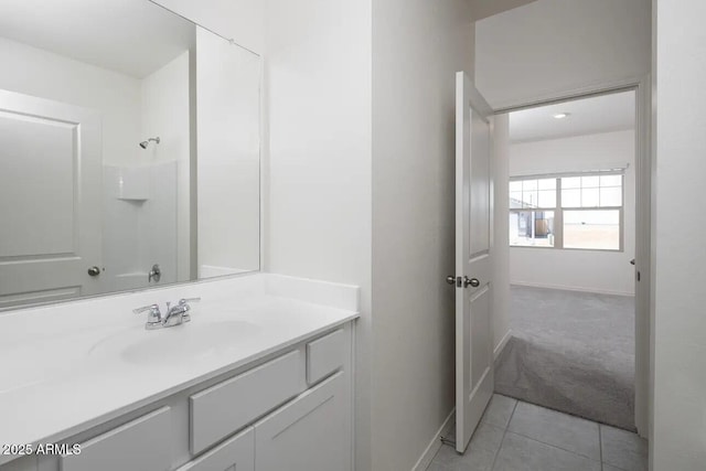 full bath with vanity, a shower, baseboards, and tile patterned flooring