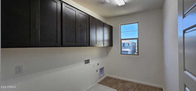 clothes washing area with electric dryer hookup, washer hookup, hardwood / wood-style floors, and cabinets