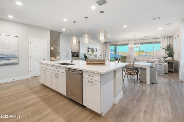 kitchen with white cabinetry, stainless steel dishwasher, sink, and a kitchen island with sink