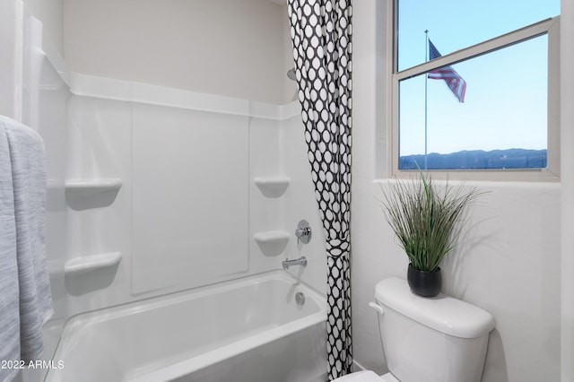 bathroom with shower / bath combination with curtain and toilet