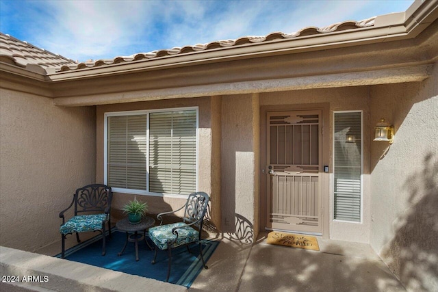 view of exterior entry featuring a patio area