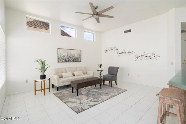 tiled living room featuring high vaulted ceiling and ceiling fan