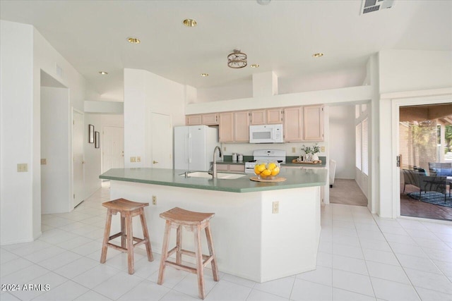 kitchen featuring light tile patterned flooring, light brown cabinetry, white appliances, and sink