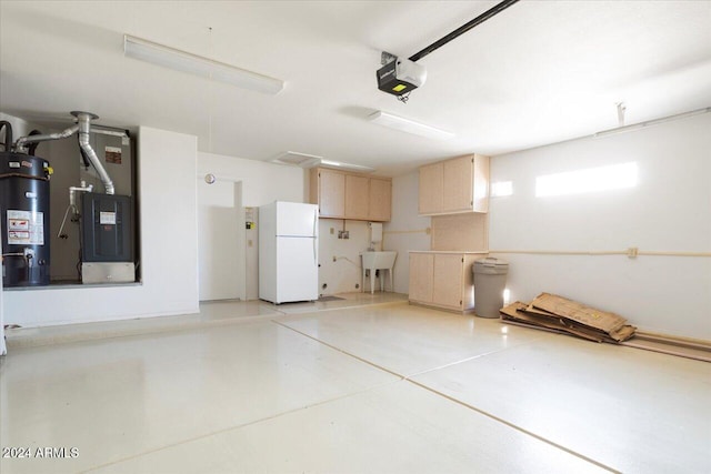 garage with heating unit, white refrigerator, water heater, sink, and a garage door opener