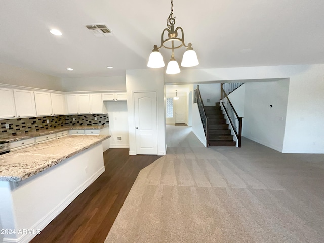 kitchen with hanging light fixtures, backsplash, white cabinetry, a chandelier, and light stone countertops