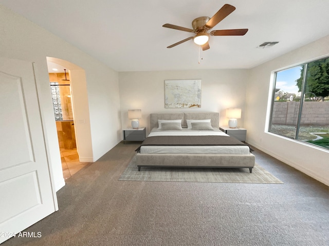 carpeted bedroom featuring ceiling fan and ensuite bathroom