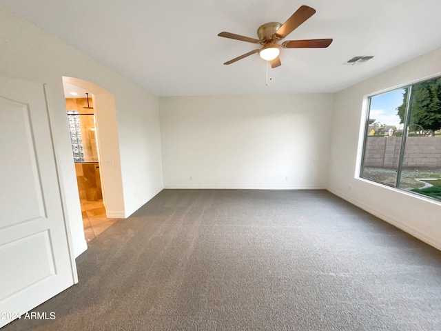 empty room with dark carpet and ceiling fan