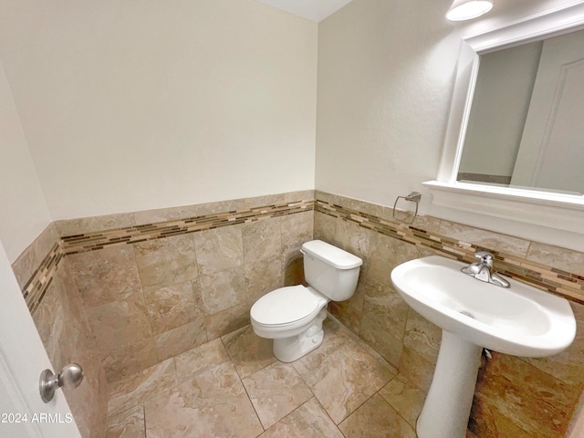 bathroom with tile walls, toilet, and tile flooring