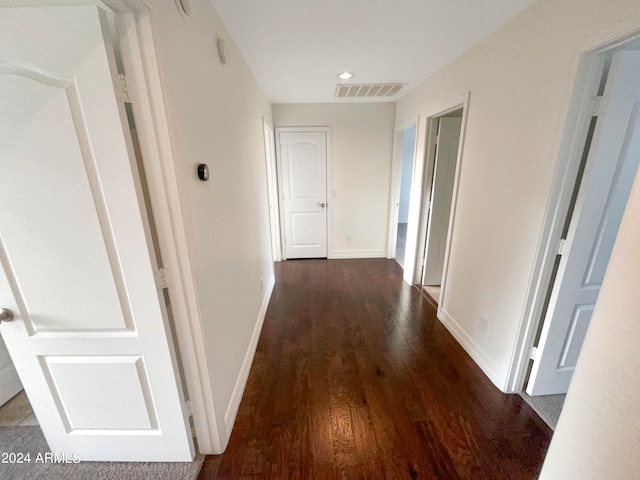 corridor with dark hardwood / wood-style flooring