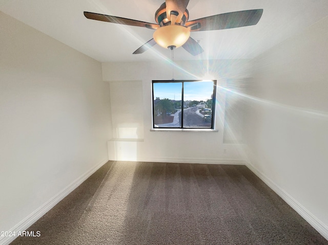 unfurnished room featuring dark carpet and ceiling fan