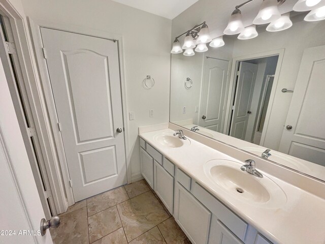 bathroom featuring oversized vanity, double sink, and tile flooring