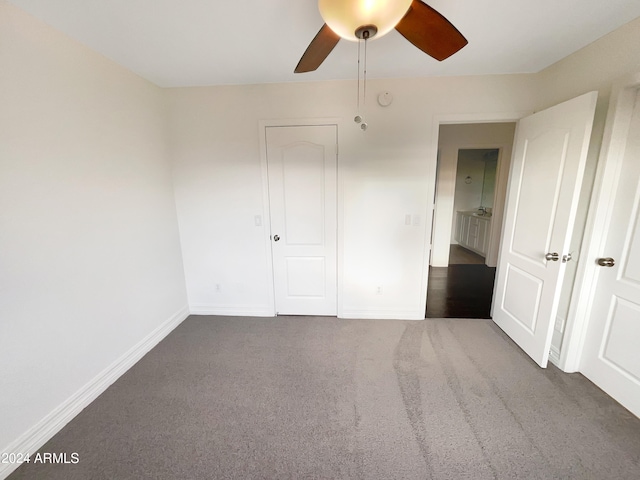 unfurnished bedroom with a closet, ceiling fan, and dark colored carpet