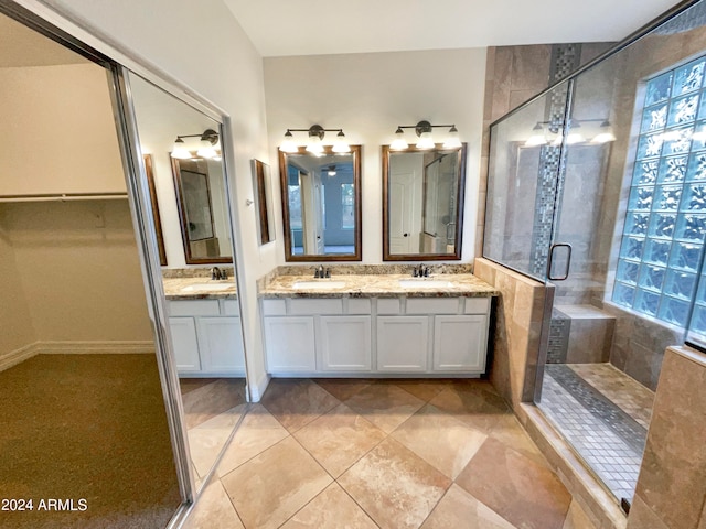 bathroom with tile flooring, an enclosed shower, and double vanity