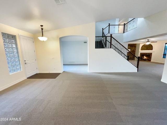 unfurnished living room featuring dark carpet and ceiling fan