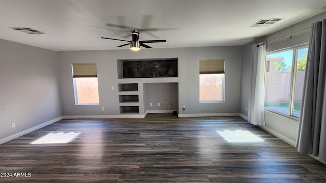 unfurnished living room featuring ceiling fan, a healthy amount of sunlight, and dark hardwood / wood-style flooring