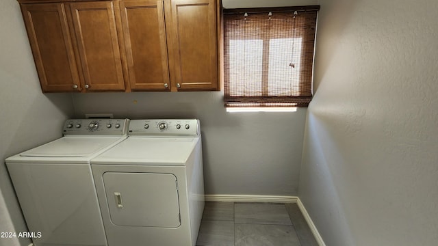 laundry area with cabinets, separate washer and dryer, and tile patterned floors