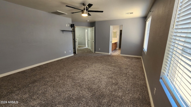 unfurnished bedroom with ceiling fan, connected bathroom, and carpet