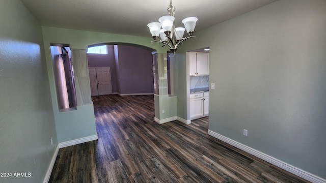 unfurnished dining area featuring dark wood-type flooring and a chandelier