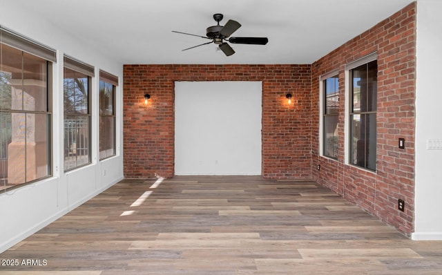 unfurnished sunroom featuring ceiling fan