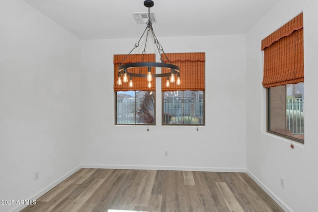 unfurnished dining area featuring visible vents, baseboards, and wood finished floors