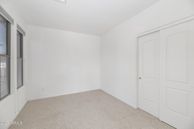 unfurnished bedroom with a closet, baseboards, and carpet floors