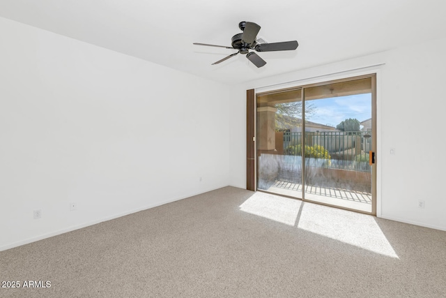 carpeted spare room featuring ceiling fan and baseboards