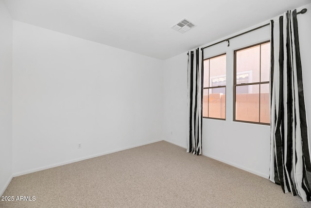 unfurnished room featuring light carpet, visible vents, and baseboards