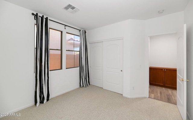 unfurnished bedroom featuring a closet, visible vents, carpet flooring, and baseboards