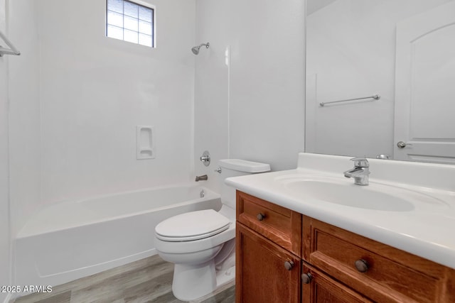 bathroom featuring vanity, toilet, wood finished floors, and washtub / shower combination