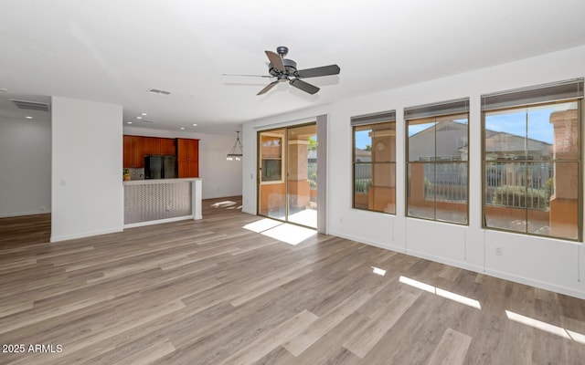 unfurnished living room featuring visible vents, baseboards, light wood-style floors, and ceiling fan