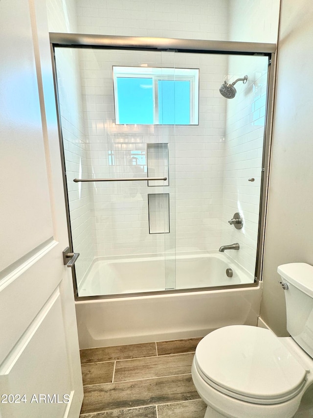 bathroom with toilet and enclosed tub / shower combo