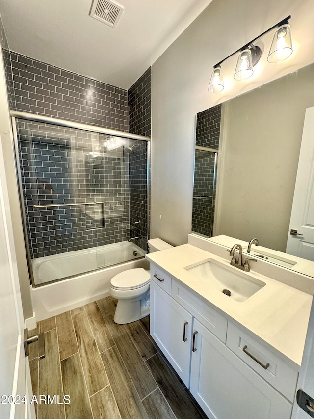 full bathroom with shower / bath combination with glass door, vanity, and toilet