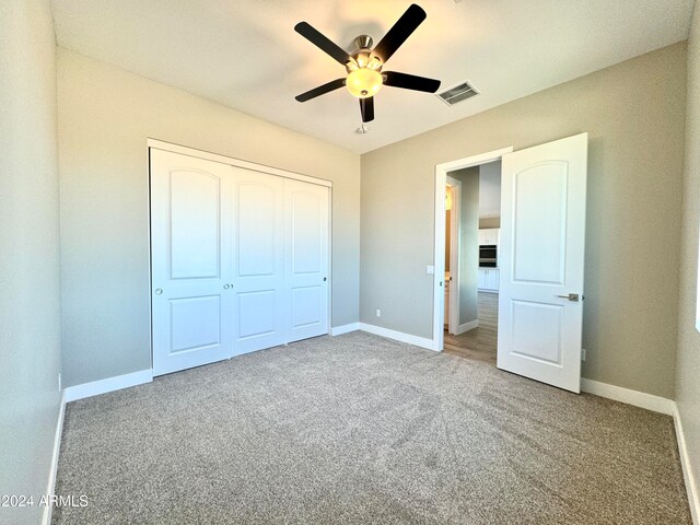 unfurnished bedroom featuring ceiling fan, a closet, and carpet floors