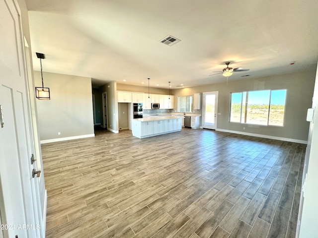 unfurnished living room with ceiling fan and light hardwood / wood-style floors