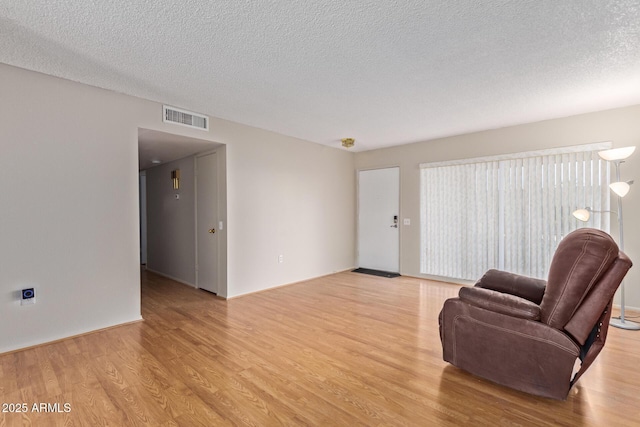 sitting room featuring a textured ceiling and light wood-type flooring