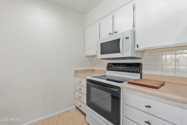 kitchen with white cabinets, electric stove, and light tile patterned floors