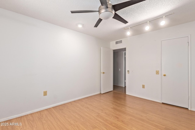 unfurnished bedroom featuring light wood-type flooring, a textured ceiling, and ceiling fan