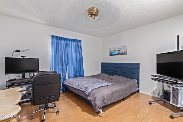 bedroom featuring a textured ceiling and hardwood / wood-style flooring