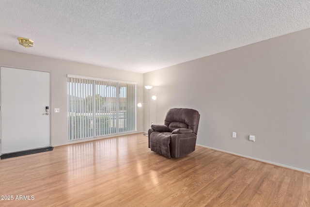 living area featuring a textured ceiling and light wood-type flooring