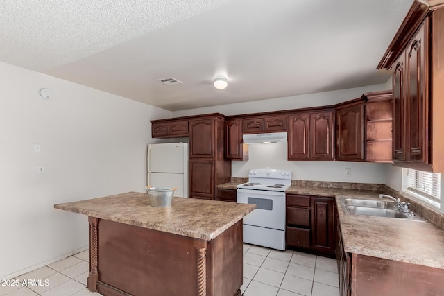 5933 W Mitchell Dr, Phoenix, AZ 85033 - kitchen with white appliances, under cabinet range hood, light tile patterned floors, a center island, and light countertops