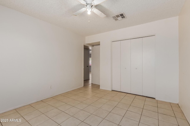 5933 W Mitchell Dr, Phoenix, AZ 85033 - unfurnished bedroom featuring a textured ceiling, a closet, ceiling fan, and light tile patterned floors