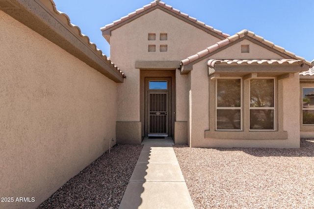 15874 W Wildflower Dr, Surprise, AZ 85374 - view of exterior entry featuring a tiled roof and stucco siding