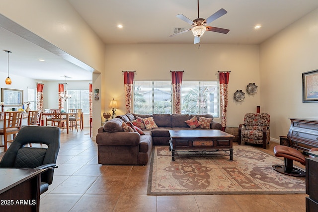 living room featuring light tile patterned floors, a towering ceiling, and ceiling fan