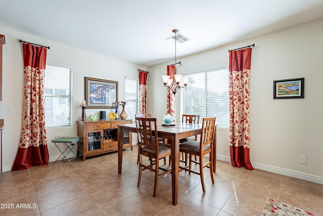 tiled dining space featuring a wealth of natural light and a notable chandelier