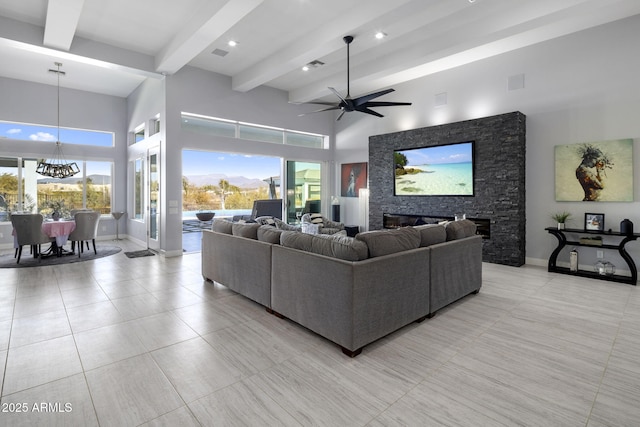 tiled living room with ceiling fan with notable chandelier, beamed ceiling, and a high ceiling