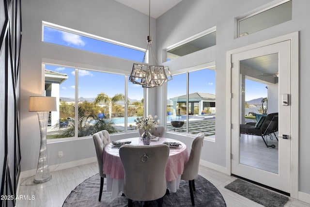 dining space with an inviting chandelier, a towering ceiling, and a water view